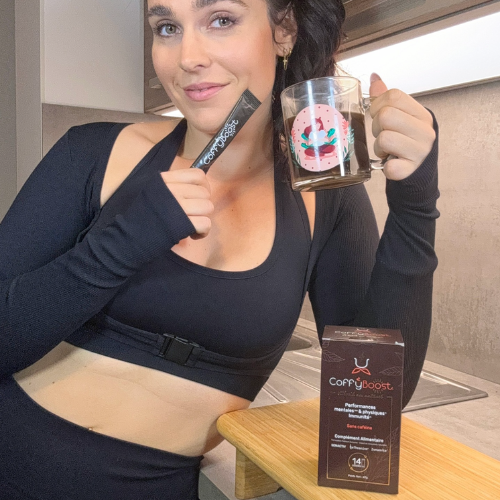 Femme tenant un sachet et une tasse de CoffyBoost French Vitality, alternative au café sans caféine pour performances mentales et physiques